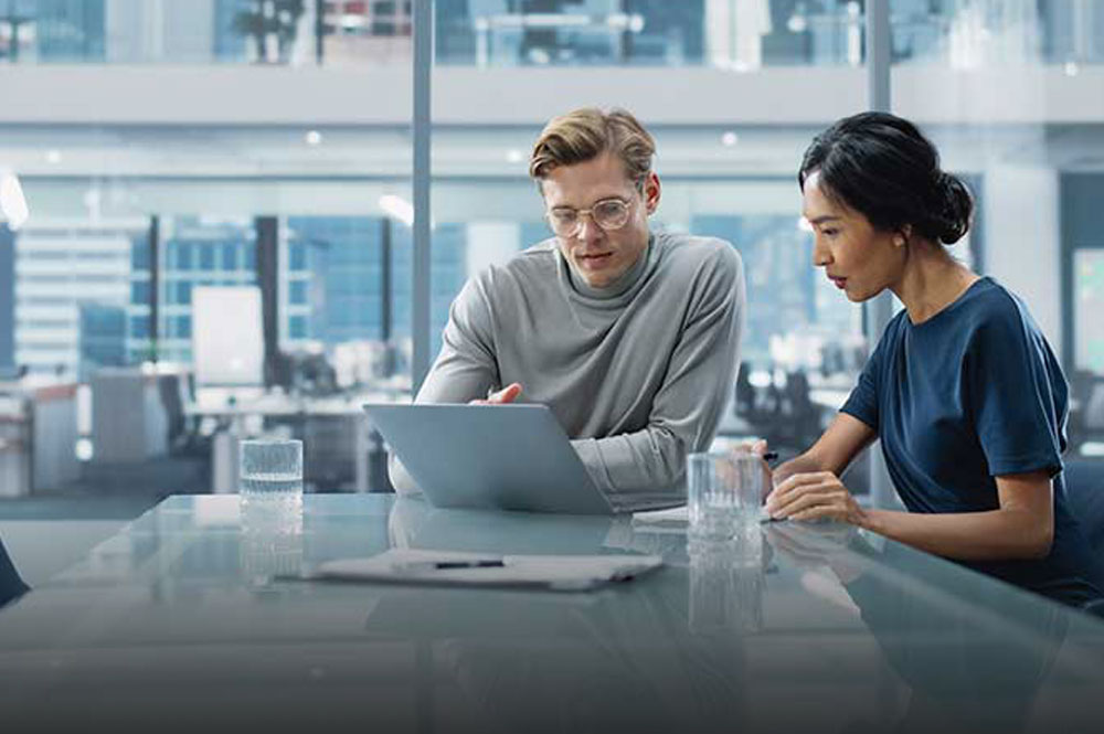 Two professionals working in a small meeting room